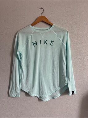 XL Nike Girl's Dri-FIT Trophy Long Sleeve Shirt features a curved hem